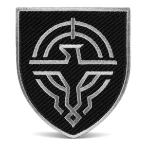 Peut inclure: Écusson brodé noir et argent en forme de bouclier. Le patch présente un emblème stylisé avec un design géométrique. L'emblème a un contour argenté et est placé sur un fond noir. Le patch a une bordure argentée.