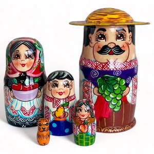 Könnte beinhalten: Satz von fünf traditionellen russischen Nistpuppen, auch Matrjoschka-Puppen genannt. Die größte Puppe ist ein Mann mit einem Strohhut, der eine Traube hält. Die anderen Puppen sind eine Frau mit einer Schüssel Obst, eine Frau mit einer Birne, eine Frau mit einem Pfirsich und eine Katze.