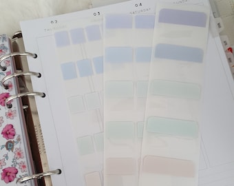 Pode incluir: Um planejador com páginas abertas e várias tiras de notas adesivas em tons pastel. As notas adesivas são retangulares e vêm em tons de azul, verde, rosa e roxo. O planejador tem um design floral na capa.