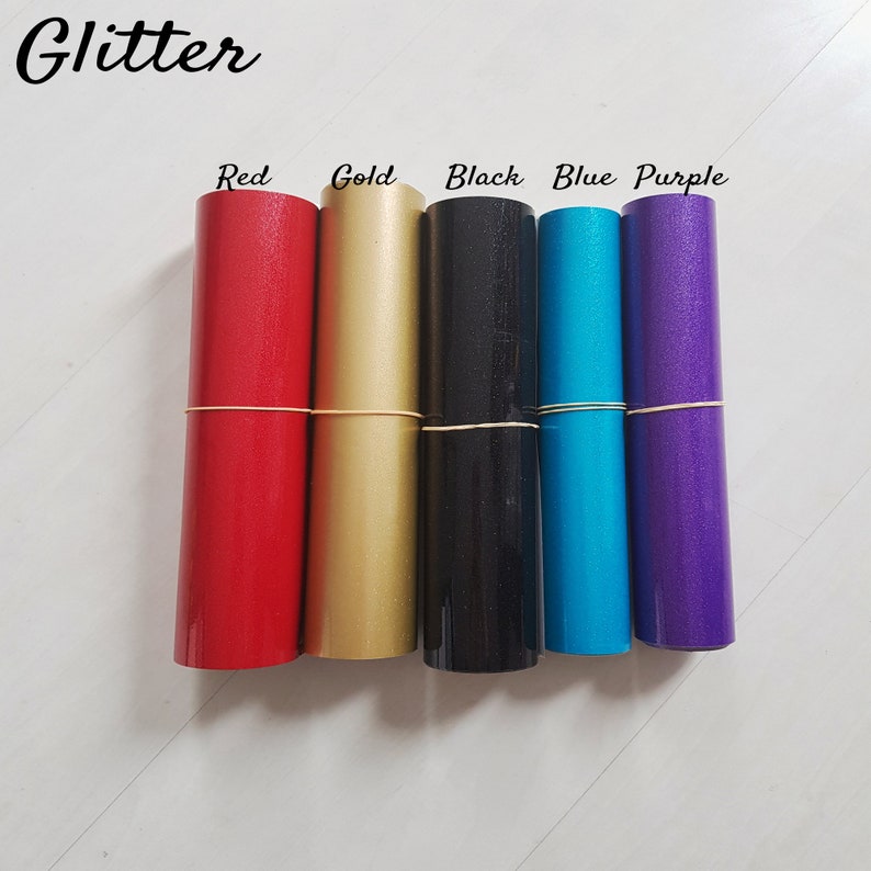 May include: Five rolls of glitter adhesive vinyl in red, gold, black, blue, and purple. The rolls are labeled with the color name.