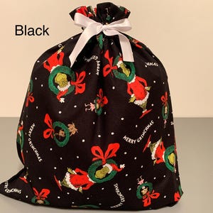 May include: Black fabric gift bag with a white ribbon closure. The bag is patterned with a repeating design of a green Grinch character wearing a red Santa suit and holding a wreath. The words "Merry Grinchmas" are also printed on the bag.