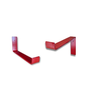 Op de afbeelding: Twee rode metalen plankdragers. Elke beugel is L-vormig, met een platte bovenkant en een verticale steun. De beugels zijn effen rood geverfd en hebben voorgeboorde gaten voor montage. Deze beugels zijn ontworpen voor het ondersteunen van planken.
