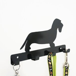 Angled side view black wire haired dachshund leash holder, flat cut-out profile with leashes on hooks