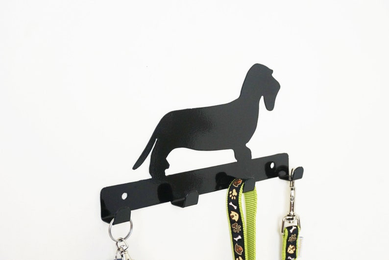 Angled side view black wire haired dachshund leash holder, flat cut-out profile with leashes on hooks