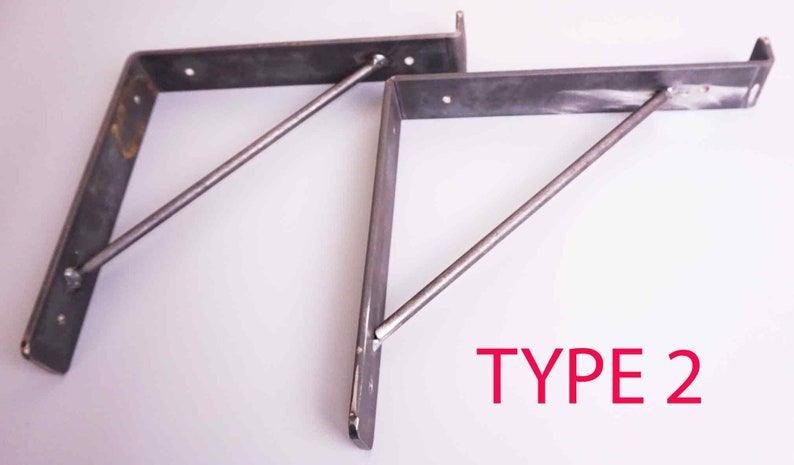K&ouml;nnte beinhalten: Zwei Metall-Regalhalterungen mit einer diagonalen St&uuml;tzstange. Die Halterungen sind hellgrau und die St&uuml;tzstange ist dunkelgrau. Der Text "TYPE 2" ist in Rot unter den Halterungen gedruckt.