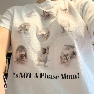 Pode incluir: Camiseta branca com um gr&aacute;fico de v&aacute;rios ratos e o texto "It's NOT A Phase Mom!"