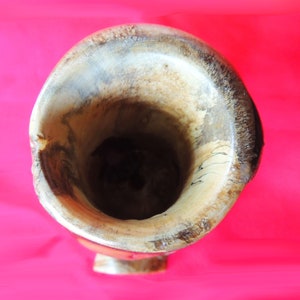 K&ouml;nnte beinhalten: Nahaufnahme des Inneren einer Holzvase. Die Vase ist aus hellbraunem Holz mit dunkelbraunen Streifen. Das Innere der Vase ist leer.