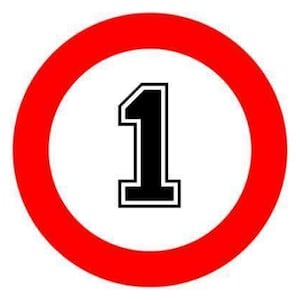 Puede incluir: Un letrero circular con un borde rojo grueso que rodea un centro blanco. En el medio del espacio blanco, hay un número uno grande de color negro con un contorno blanco fino y un borde negro, creando un gráfico claro y contrastado.