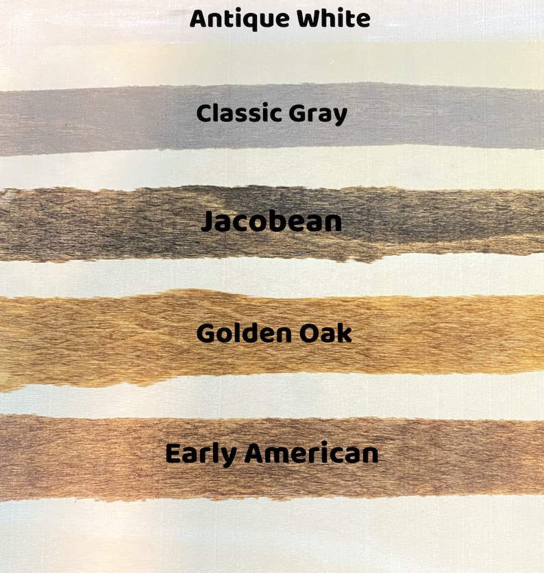 May include: Five wood stain samples on a white surface. The samples are labeled "Antique White", "Classic Gray", "Jacobean", "Golden Oak", and "Early American".