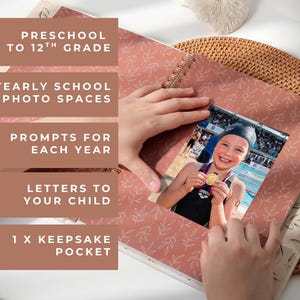 May include: A photo album with a pink cover featuring a leaf pattern. The album includes photo spaces, prompts, and a keepsake pocket. The image shows a child holding a medal. Text on the album reads: Preschool to 12th Grade.