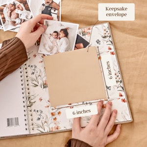 K&ouml;nnte beinhalten: Ein beigefarbener Erinnerungs-Umschlag mit einem Blumenmuster. Der Umschlag ist 15,2 cm x 15,2 cm gro&szlig; und wird von einer Hand gehalten. Der Text "Keepsake envelope" steht auf dem Umschlag.