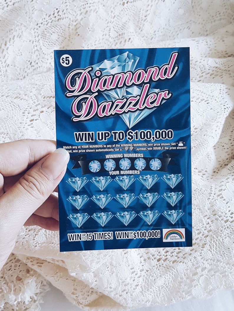 Pu&ograve; includere: Un biglietto della lotteria blu e rosa con le parole "Diamond Dazzler" e "Vinci fino a 100.000 &euro;". Il biglietto ha una griglia di diamanti con numeri da abbinare.