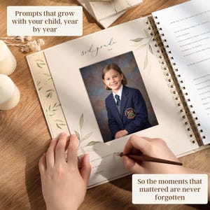 May include: A spiral-bound memory book with a photo of a child in a school uniform. The book is open, with text that reads "Prompts that grow with your child, year by year" and "So the moments that mattered are never forgotten."