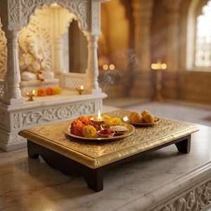 Pode incluir: Uma mesa dourada e ornamentada exibe um prato com flores, uma vela acesa e pequenas tigelas. Um santuário de mármore com uma estátua está ao fundo. A fumaça de incenso cria uma atmosfera serena.