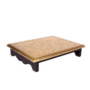 May include: A rectangular, decorative wooden table with a gold-coloured, embossed metal top. The table has dark brown legs and a gold border. The embossed design on the top features intricate patterns. The table is designed to be a decorative accent piece.