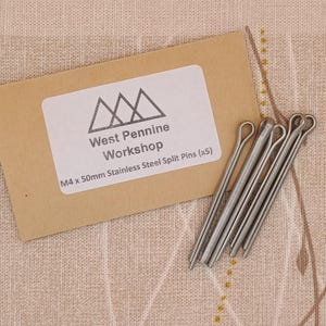 Könnte beinhalten: Eine Packung mit fünf 4 mm x 50 mm Edelstahl-Splinten von West Pennine Workshop. Die Verpackung ist braun mit einem weißen Etikett, auf dem das Firmenlogo und Produktinformationen abgebildet sind.