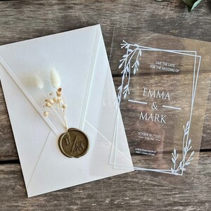 Cartão de convite transparente com selo, envelope branco e flores secas