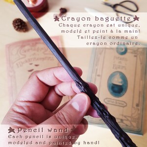 May include: A black crayon pencil wand with a unique, hand-painted design. The text on the image reads "Crayon baguette" and "Each pencil is unique, modeled and painted by hand! Sharpen it like an ordinary pencil."