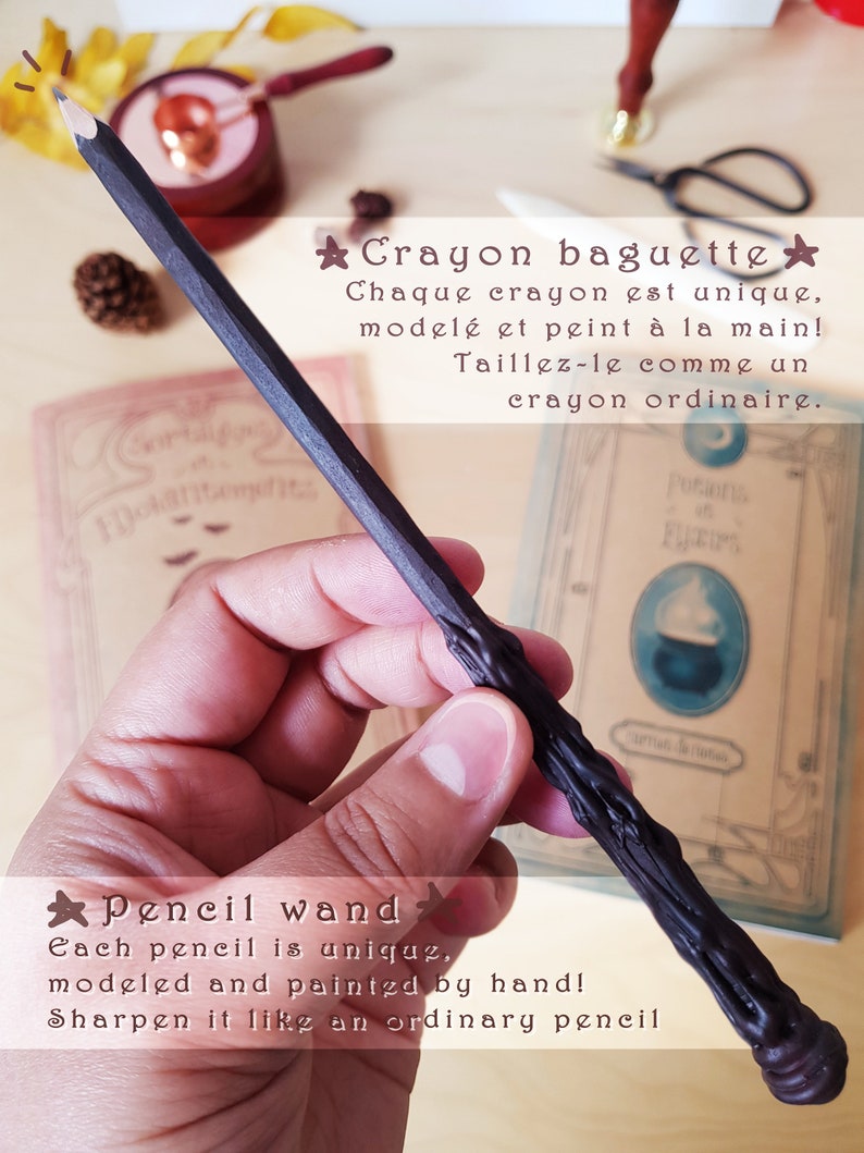 May include: A black crayon pencil wand with a unique, hand-painted design. The text on the image reads "Crayon baguette" and "Each pencil is unique, modeled and painted by hand! Sharpen it like an ordinary pencil."