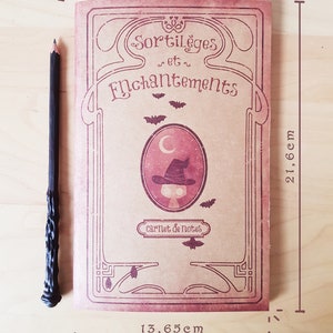 May include: A vintage-style notebook with a brown cover and a decorative border. The cover features the text "Sortil&egrave;ges et Enchantements" and a small illustration of a witch's hat. The notebook is 13.65 inches wide and 21.6 centimeters tall.