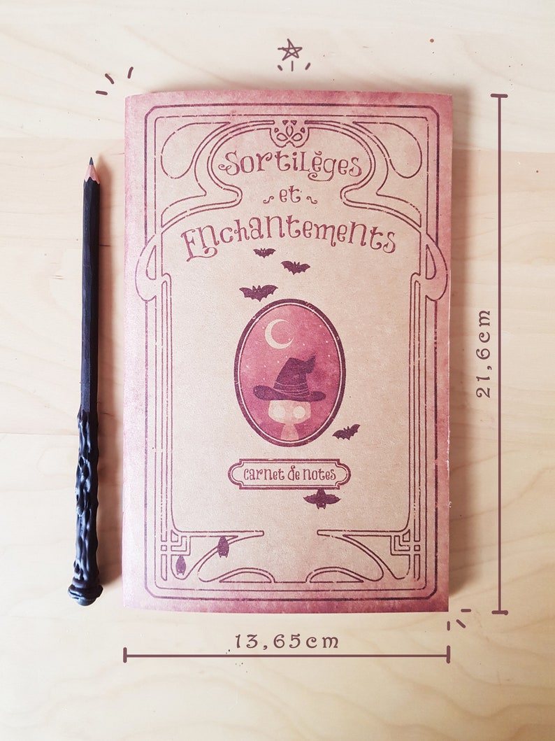 May include: A vintage-style notebook with a brown cover and a decorative border. The cover features the text "Sortil&egrave;ges et Enchantements" and a small illustration of a witch's hat. The notebook is 13.65 inches wide and 21.6 centimeters tall.