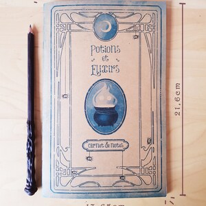 May include: A brown notebook with a blue and white design. The cover features a cauldron, a crescent moon, and the text "Potions et Elixirs" in a decorative font. The notebook is 13.65 inches wide and 21.66 inches tall.