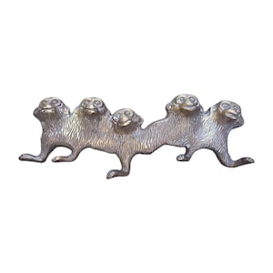 May include: A detailed, antique-style metal sculpture of five monkeys linked together. The monkeys are depicted in a walking pose, with textured fur and expressive faces. The sculpture has a bronze-like finish.