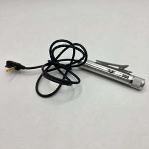 May include: A silver-colored cylindrical microphone with a metal pocket clip and a textured end cap. The device is attached to a long, thin black cable that terminates in a gold-plated multi-pin connector plug for audio input.