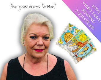 May include: A woman with blonde hair and red lipstick is looking at the camera. She is holding three tarot cards: The Wheel of Fortune, The Sun, and The World. The text "Love Video Tarot Reading 2 Questions" is in the upper right corner of the image.