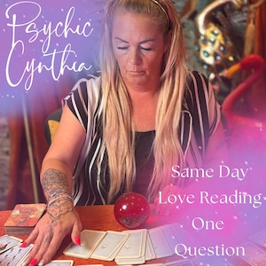 May include: A woman with long blonde hair and a black and white striped top is seated at a table with tarot cards. The text "Psychic Cynthia" is at the top left. The text "Same Day Love Reading One Question" is on the right.