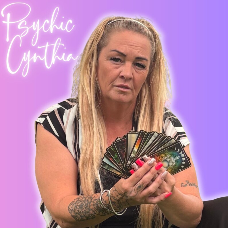 May include: A woman with long blonde hair holds a deck of tarot cards. The image has a purple and pink gradient background. The text "Psychic Cynthia" is written in a cursive font in the upper left corner.