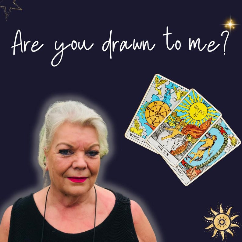 Puede incluir: Una mujer con cabello gris y un top negro sin mangas mira a la c&aacute;mara. Detr&aacute;s de ella hay tres cartas de tarot: La Rueda de la Fortuna, El Sol y El Mundo. El texto "Are you drawn to me?" est&aacute; escrito en blanco en la parte superior de la imagen.