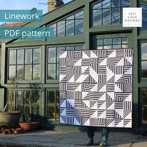 Peut inclure: Une courtepointe carrée présentant un motif géométrique noir et blanc composé de rayures alternées et de blocs solides. La courtepointe est tenue devant une grande structure vitrée à cadre vert. Le texte indique Linework PDF pattern et Cait Lisle Designs.