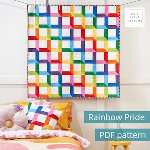 May include: A square quilt featuring a geometric pattern of interlocking rainbow-colored squares on a white background, finished with a multi-colored striped border. The text Cait Lisle Designs appears in the top right corner of the image.