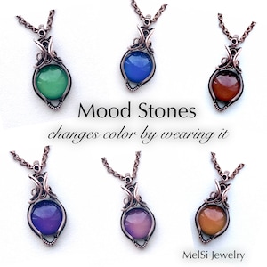 May include: Six mood stone necklaces with copper wire settings. The stones change color based on body temperature. The stones are green, blue, orange, purple, pink, and brown.