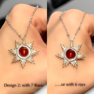 May include: Two silver necklaces with a red gemstone sun pendant. The pendant on the left has seven rays and the pendant on the right has six rays.  Design 2: with 7 Rays.....or with 6 rays