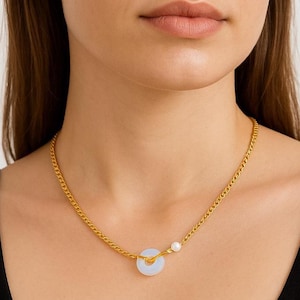 May include: A gold chain necklace with a white jade pendant and a single pearl accent.