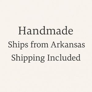 May include: Text on a cream-colored background reads "Handmade Ships from Arkansas Shipping Included" in a simple, elegant font. The text is centered and in a dark color, likely black or a very dark shade.