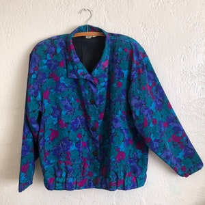 May include: A blue, pink, and green floral print button-up jacket with a gathered elastic waistband.