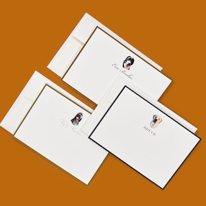 May include: Stationery set featuring custom dog portraits. The set includes white notecards with colored borders and matching envelopes. Each card has a watercolor illustration of a dog's face and a name. The names on the cards are "Eva Boucher", "Katie Kinton", and "Bruce".