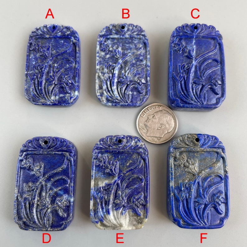 May include: Six carved lapis lazuli pendants with a floral design. The pendants are rectangular and have a hole at the top for hanging. The pendants are labeled A through F.