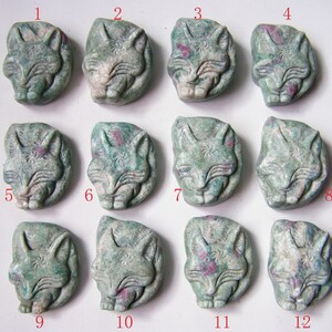 Puede incluir: Doce figuritas de zorro de piedra tallada, verdes y blancas, cada una con un diseño y un patrón diferente. Las figuritas están numeradas del 1 al 12.