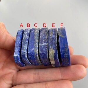 May include: Six rectangular lapis lazuli stones, each with a different shade of blue and white, arranged in a row labeled A through F.