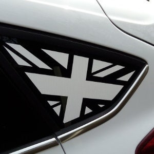 以下が含まれることがあります： リアウィンドウに黒と白のユニオンジャックのステッカーが貼られた白い車