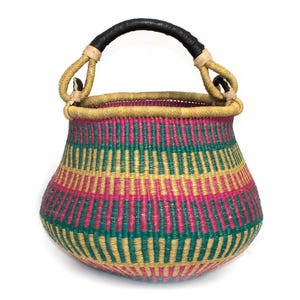 May include: A colourful, handwoven basket with a rounded form and a strong handle. The basket displays horizontal stripes in pink, green, and yellow. The handle is black with tan details, and the rim has a golden trim.