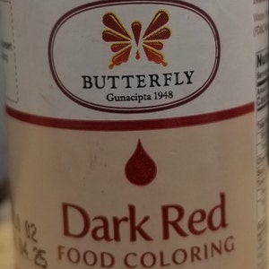 May include: A 1-fluid ounce bottle of dark red food coloring. The bottle has a white label with a butterfly logo and the text "BUTTERFLY Gunacipta 1948". The label also includes the text "Dark Red Food Coloring" and "NET VOLUME: 1 fl.oz (30ml)".