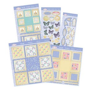 May include: A collection of decorative paper sheets with various designs. The sheets feature framed images of cakes, rainbows, and butterflies in pastel colors. Some sheets include die-cut shapes and stickers, perfect for scrapbooking or crafting projects.