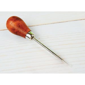 May include: A leathercraft awl with a wooden handle and a silver metal shaft. The handle is a dark brown color and has a smooth, rounded shape. The awl is designed for piercing leather and other materials.