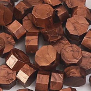 May include: A collection of small, octagonal wax seal beads in a metallic copper finish. Each bead features a flat top and bottom with faceted sides, displaying a reflective, textured surface with subtle variations in the bronze-toned color.