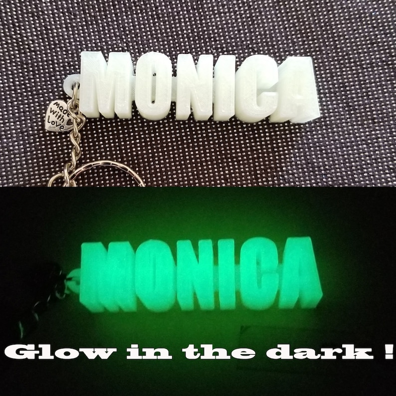 May include: White plastic keychain with the name "MONICA" in block letters. The keychain glows green in the dark. The keychain has a small charm that says "Made with Love".